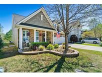 Charming home featuring brick accents, a landscaped front yard, and an inviting covered porch, enhancing its curb appeal at 152 Blossom Ridge Dr, Mooresville, NC 28117