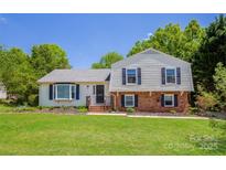 Charming two-story home with lush green lawn, manicured landscaping, and inviting front porch at 1637 Buckingham Ave, Gastonia, NC 28054
