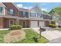 Charming brick townhome with green shutters, garage and well maintained landscaping on a sunny day at 2059 Lennox Square Rd, Charlotte, NC 28210