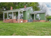 Charming green home with a welcoming front porch and well-maintained lawn at 211 Hershel Lackey Rd, Lincolnton, NC 28092