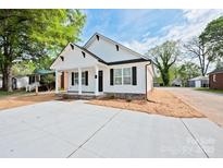 Charming single-story home with a white exterior, black shutters, and a well-manicured front yard at 417 Spring Sw St, Concord, NC 28025