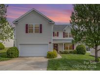 Charming two-story home features a well-maintained lawn, a two-car garage, and red window shutters at 428 Whitewater Nw Way, Concord, NC 28027