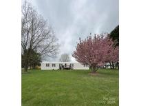 Inviting single-story home with a blossoming pink tree and a well-maintained lawn at 5767 Swinging Bridge Rd, Conover, NC 28613