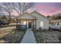 Charming single-story home with black porch and a walkway leading up to the front door at 705 Sumter St, Lancaster, SC 29720