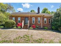 Charming brick home featuring a well-maintained lawn, red flower bushes, and a classic chimney at 73 Wyth Sw Ct, Concord, NC 28025