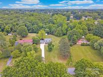 Expansive aerial view of property surrounded by lush greenery and a long driveway leading to the home at 915 Gate Rd, Monroe, NC 28112