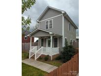 Charming two-story home with a welcoming front porch and landscaped yard, perfect for relaxing outdoors at 932 3Rd Street Sw Pl, Hickory, NC 28602