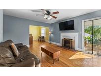 Comfortable living room with hardwood floors, fireplace, ceiling fan and view of dining room at 1068 14Th Nw Ave, Hickory, NC 28601