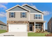 Two-story home featuring stone accents, gray siding, a two-car garage, and well-maintained landscaping at 133 Falling Up Ln, Salisbury, NC 28147