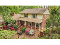 Charming brick home with a front porch, lush landscaping, and a welcoming curb appeal at 147 Spring Shore Rd, Statesville, NC 28677