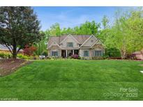 Charming home features a well-manicured lawn and inviting stone and shingle exterior with blue shutters at 1813 Wedowee Ct, Rock Hill, SC 29732