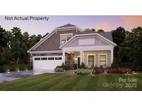 Charming two-story home featuring a manicured lawn, stone accents, a covered porch and an attached two car garage at 2 Five Creek Rd # 2, Charlotte, NC 28213