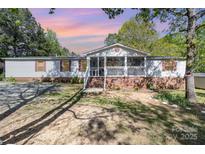 Charming single-story home boasts a screened porch and lush landscaping in a serene setting at 3536 Minnow Bridge Rd, Carlisle, SC 29031
