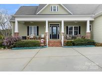Charming front porch with brick accents and comfortable seating area at 557 Luther Dr, Iron Station, NC 28080