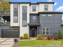 Contemporary two-story home showcasing modern design and landscaping with a garage and outdoor deck at 913 Van Every St, Charlotte, NC 28205