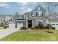 Charming two-story home with a stone facade, manicured lawn, and a welcoming front entrance at 1005 Argentium Way, Waxhaw, NC 28173