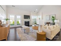 Bright living room features a fireplace, French doors, and neutral decor at 1005 Argentium Way, Waxhaw, NC 28173