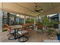 Inviting outdoor patio with a dining area, comfortable seating, and a ceiling fan for relaxing and entertaining at 10072 Fox Trotter Ln, Midland, NC 28107