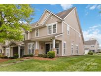 Charming townhome featuring manicured lawn, covered porch, and neutral siding, perfect for comfortable living at 1013 Laparc Ln, Indian Trail, NC 28079