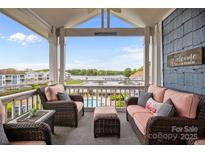 Inviting porch with lake views, wicker furniture, and a cozy seating area at 1033 Southwest Dr, Davidson, NC 28036