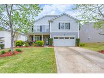 Charming two-story home with a well-manicured lawn, two car garage, and tasteful landscaping at 1144 Spicewood Pines Rd, Fort Mill, SC 29708