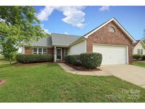 Charming single-story brick home featuring a well-manicured lawn and an attached two-car garage at 11623 Black Maple Ave, Charlotte, NC 28269