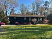 Charming single-story home featuring a well-manicured lawn and mature trees at 119 Meadowbrook Ln, Davidson, NC 28036