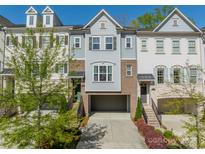 Charming townhome with brick and siding exterior, featuring an attached garage and manicured landscaping at 15133 Rocky Bluff Loop, Davidson, NC 28036