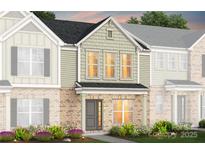 Charming townhome featuring brick facade, complemented by well-maintained landscaping at 2208 Cobble Ct # 161, Monroe, NC 28110