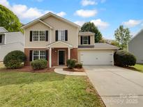 Charming two-story home featuring a classic design, attached two-car garage, manicured front lawn, and traditional architectural details at 614 Saratoga Dr, Clover, SC 29710