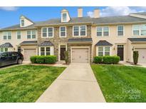 Charming townhouse showcasing a stone facade, two-car garage, and well-manicured lawn at 9618 Springholm Dr, Charlotte, NC 28278