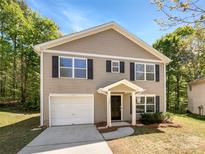 Charming two-story home with neutral siding, black shutters, and an attached one car garage at 1107 Stonehenge Ln, Charlotte, NC 28216