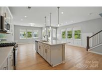 A bright kitchen with a kitchen island, hardwood floors, recessed lighting, and stainless steel appliances at 134 Berkeley Ave, Mooresville, NC 28117