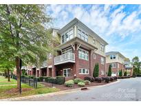 Beautiful brick townhome with a balcony, manicured landscaping, and a well-maintained exterior at 1412 W 4Th St, Charlotte, NC 28208