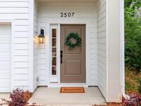 Inviting front entrance with a tan door, classic black lantern, and decorative green wreath at 2507 Elon St, Charlotte, NC 28208