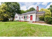 Charming single-Gathering home with red accents, mature trees, and a welcoming covered porch at 606 W 19Th Ave, Gastonia, NC 28052