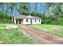 Charming home with freshly cut lawn and dirt driveway surrounded by mature trees at 817 32Nd Street Ne Dr, Conover, NC 28613