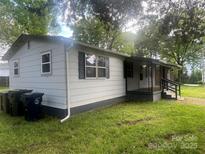 Charming single-story home with neutral siding, a screened-in porch, and a well-maintained lawn at 20016 Walter Henderson Rd, Cornelius, NC 28031