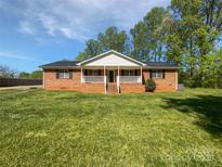 Charming brick home featuring a welcoming front porch and a spacious lawn at 2035 Mauney Rd, Bessemer City, NC 28016