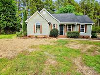 Charming home features sage green siding, decorative shutters, and a well-maintained front yard with fresh mulch at 213 Meadow Wind Ct, Monroe, NC 28110