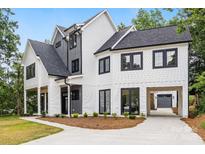 Stunning two-story home with white siding, dark trim, covered parking, and manicured landscaping at 2200 Stratford Ave, Charlotte, NC 28205