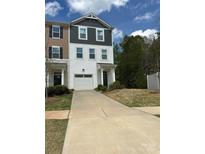 View of a well-maintained townhome with a driveway and attached garage on a sunny day at 2932 Pirates Pl, Charlotte, NC 28216