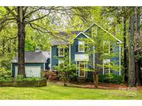 Charming blue two-story home with lush landscaping and a side-entry garage, offering curb appeal at 3005 Kenninghall Ct, Charlotte, NC 28269