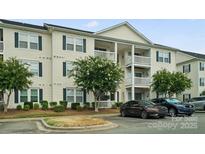 Inviting multi-story condo with white siding, dark shutters, and well-maintained landscaping at 3849 Carl Parmer Dr, Harrisburg, NC 28075