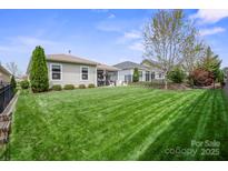Well-maintained backyard with lush green grass, landscaping, and a patio area perfect for outdoor entertaining at 4831 Looking Glass Trl, Denver, NC 28037