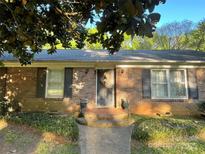 Charming brick home with a welcoming front porch and mature landscaping, creating excellent curb appeal at 729 Aintree Rd, Charlotte, NC 28215