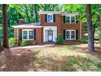 Charming two-story brick home with black shutters and well-manicured landscaping at 8807 Tree Haven Dr, Charlotte, NC 28270