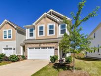 Charming two-story home with a stone accent garage, neutral siding, a tree, and a well-manicured lawn at 9134 Northfield Crossing Dr, Charlotte, NC 28269