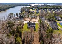 A home with a big lawn and a covered porch in a rural area near a lake at 13453 Portside Ln, Lancaster, SC 29720