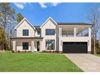 Beautiful two-story modern farmhouse featuring a black garage door and spacious front lawn at 13453 Portside Ln, Lancaster, SC 29720